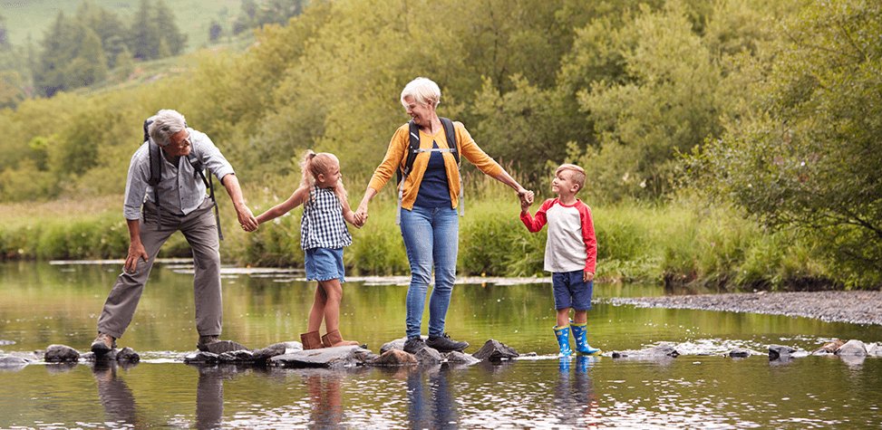 grandparents with children at the river